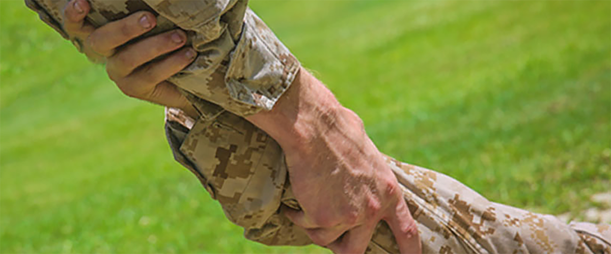 Marine giving a helping hand to another Marine.